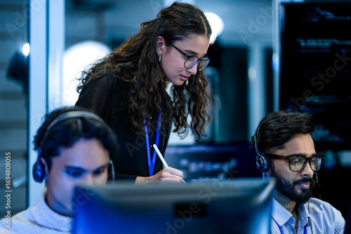 Papier peint A team leader trains a new customer service agent in a modern call center