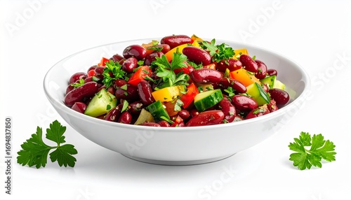 Fresh red kidney bean salad with cucumber, bell peppers, and parsley in a white bowl, isolated on a white background.