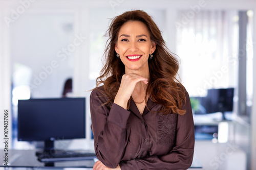 Cropped shot of a businesswoman standing at the office and smiling at camera
