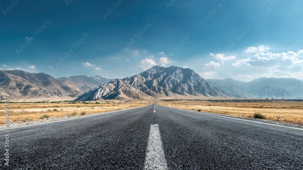 Naklejka premium Straight road disappearing into the distance, mountain landscape