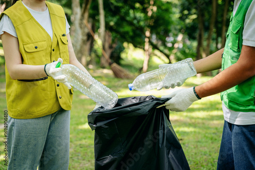 Cuadro en lienzo Dedicated volunteers collect plastic bottles for recycling in a public park prom