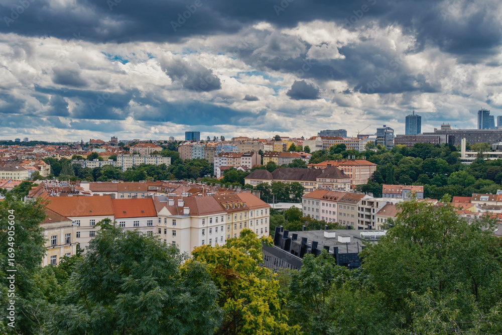 Obraz premium Breathtaking panoramic view of Prague, showcasing its historic city center with iconic buildings, charming red-roofed houses.