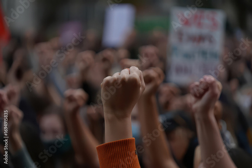 Crowd of people raising fists in the air at a protest