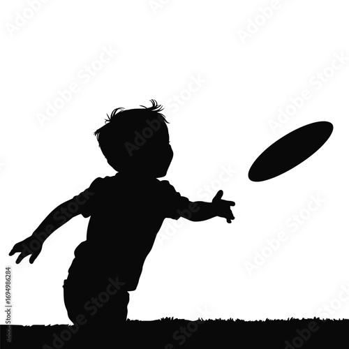 Silhouette of a Young Boy Tossing a Frisbee Outdoors with Grass