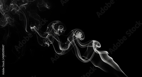 An abstract monochrome image showing swirling patterns of smoke against a black background space