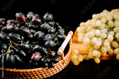 Photos Ripe grapes in a basket with green and black varieties displayed on a rustic woo