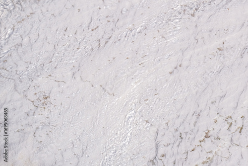Εκτύπωση καμβά Clear fresh water flows over a white natural travertine stone surface