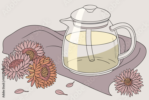 Glass teapot with yellow liquid and pink and orange gerbera daisies on a cloth pink flowers