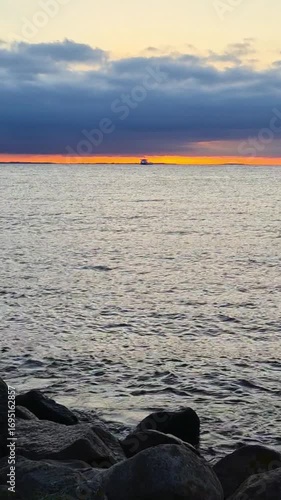 A tranquil and picturesque sunset over the ocean with a rugged and beautiful rocky shoreline