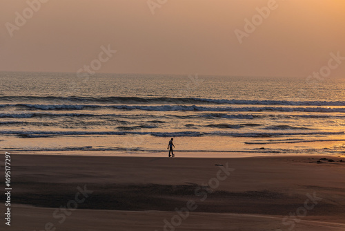 Stunning ocean view illuminated by golden sun as evening walkers enjoy peaceful surroundings.