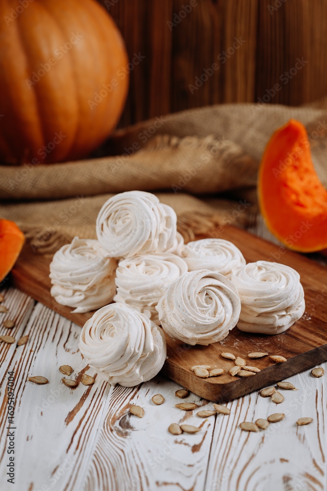Fototapeta premium Homemade marshmallow dessert with pumpkin on wooden board and rustic background