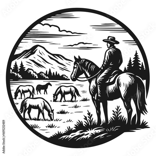 Cowboy on horseback watching grazing horses in mountain landscape