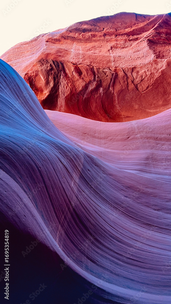 Obraz premium Purple and red sandstone formations of Antelope Canyon in Arizona illuminated by desert light, showcasing smooth textures and wave-like shapes carved by centuries of erosion into abstract patterns