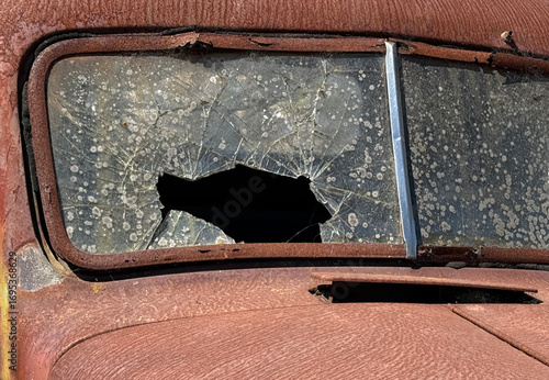 Smashed windshield on a rusted defunct antique truck