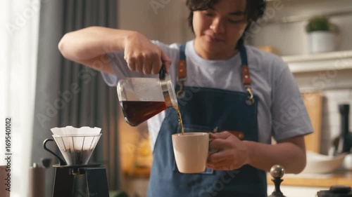 Wallpaper Mural Young Asian man making drip coffee,Grind coffee savor the aroma and flavor at home kitchen in morning vibe,cheerful barista making coffee pouring hot water into dripper,morning lifestyle vibes concept Torontodigital.ca