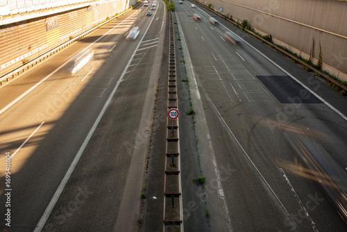 Urban highway with central 100 speed limit sign at golden hour