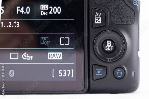 Camera LCD Screen Displaying Settings - Aperture, ISO, RAW Format, and Image Count.