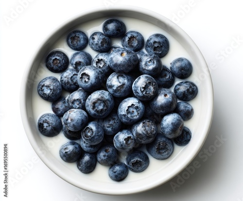 A bowl filled with blueberries in creamy liquid, top-down shot against a stark white background, minimalist