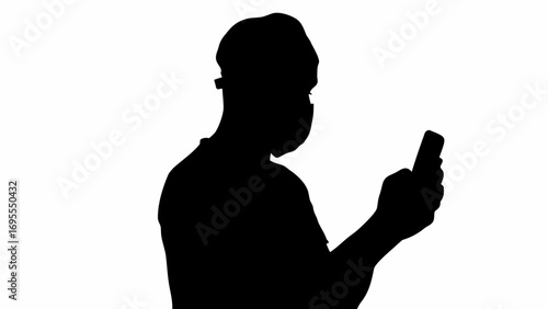 Silhouette of a person wearing a mask and holding a smartphone while looking at the screen device face on 100