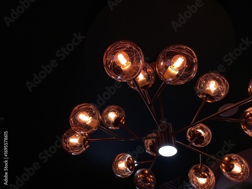 Aesthetic chandelier with a series of yellow lights and circular glass covering it