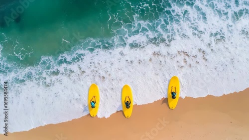 Aerial View of Surfers Enjoying Waves on a Sandy Beach