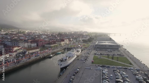 Gil Eannes ship docked in Viana do Castelo marina with the cruise terminal and historic waterfront buildings in northern Portugal - Aerial Orbit