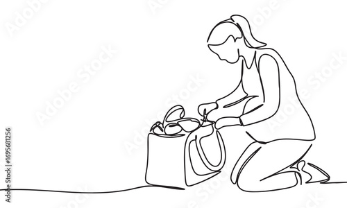 Pregnant Woman Kneeling and Organizing Items in a Bag