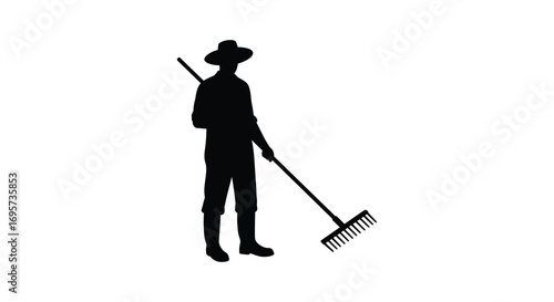 a silhouette of a person holding a rake outdoors
