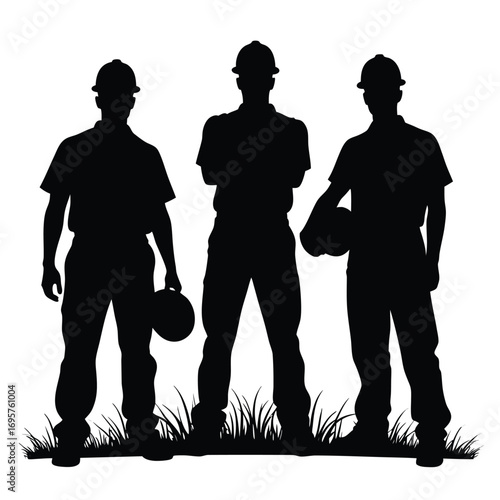 Three construction workers in silhouette with hard hats on grass