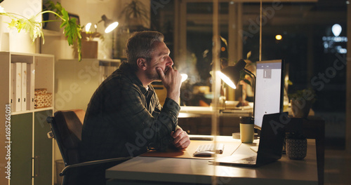 Papier peint Mature man, reading and computer at night in office with review, work article and deadline