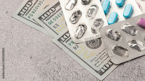 Dollar bill and a set of medicine pills. Rising costs of medical care. Reliefs for buying medicine.Pills in capsules scattered on US dollars currency.Concept of health care in USA.
