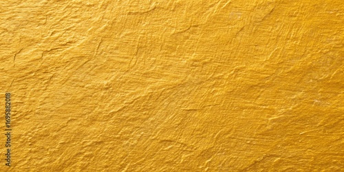 Close up full frame shot of a rich textured golden yellow abstract surface