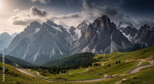 Wallpaper Mural Majestic Dolomites landscape featuring towering peaks, lush green meadows, and a winding mountain road under a dramatic, cloudy sky, evoking a sense of adventure and natural beauty. Torontodigital.ca