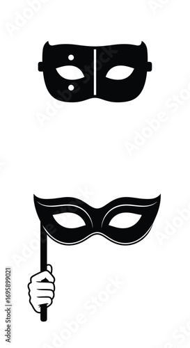 Two black masquerade masks one held by hand on a stick one for the face with eye holes and two dots above
