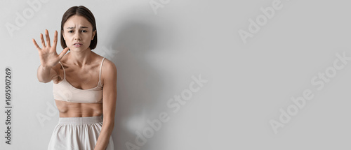 Young skinny woman on light...
