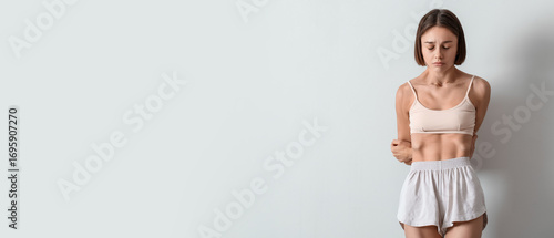 Young skinny woman on light...