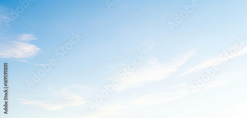 Bright blue sky filled with soft white clouds, featuring a subtle gradient effect, creating a peaceful and airy atmosphere with natural soft light and calm scenic backdrop.