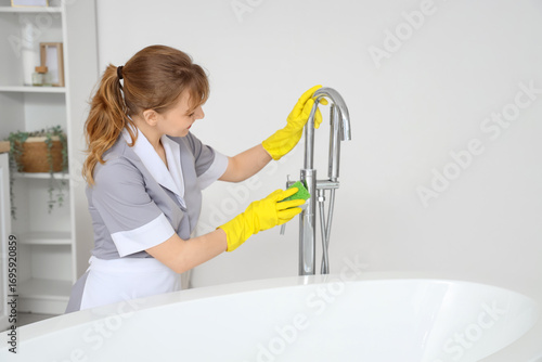 Young chambermaid cleaning ...