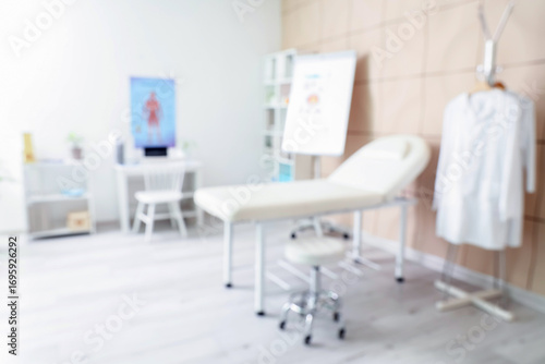 Blurred view of medical office with couch and doctor's workplace
