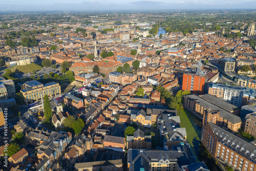 Fototapeta premium Aerial image of York showing Clifford’s Tower, historic rooftops, and modern buildings in morning sunlight.