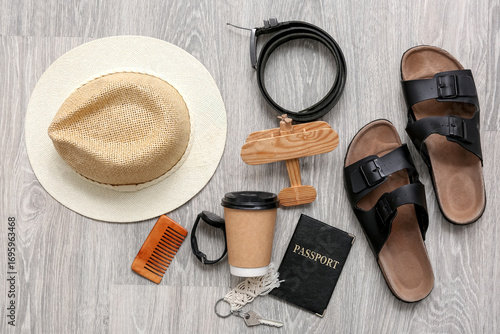 Traveler's accessories with toy airplane on light wooden floor, top view