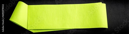 Two bright lime green sticky notes overlapping on a dark surface