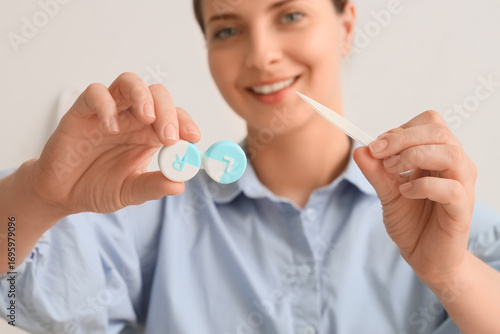 Young woman holding tweezer...
