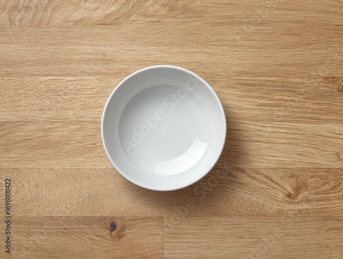 Empty white bowl on light brown wood