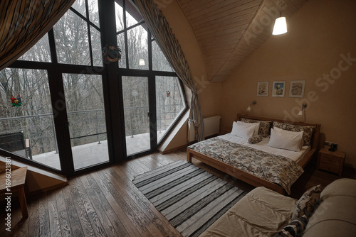 Cozy bedroom with large windows and a forest view