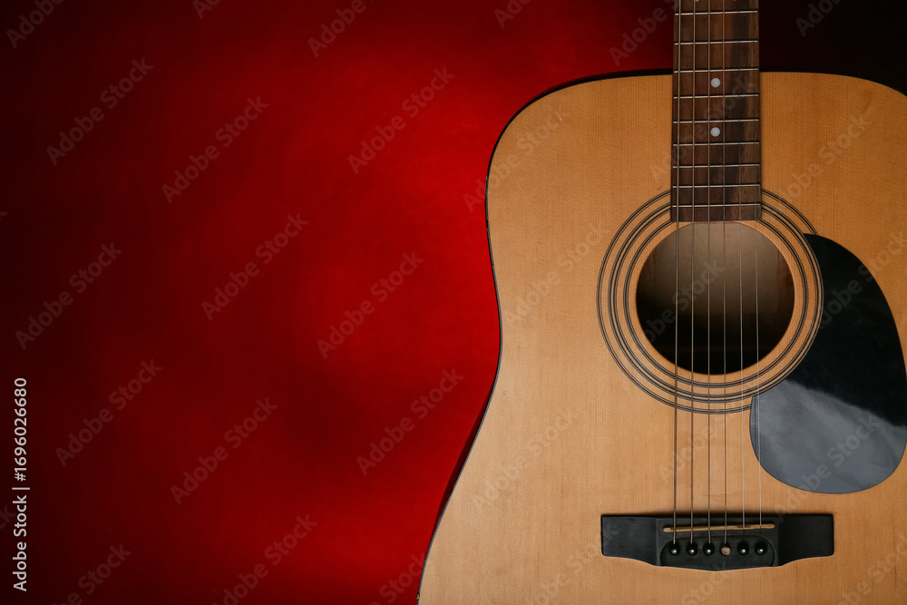 Obraz premium Modern acoustic guitar on red background, closeup