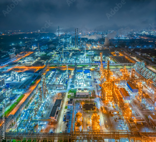 Large petrochemical plant and oil refinery complex brightly illuminated at night.