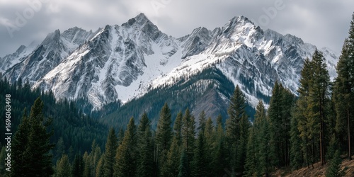 Majestic Peaks: A breathtaking panorama unveils a rugged mountain range, its peaks adorned with glistening snow, under a sky that hints at a coming storm.