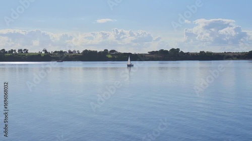 A Tranquil Seascape Featuring Sailboats Floating on the Clear Blue Water Under the Sky