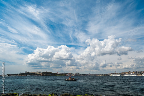 A boat is in the middle, with Galata Tower in the background and cruise ships on the right. The silhouettes of Topkapı Palace and the Sultanahmet Mosque are visible on the left. taken from Maiden's T.